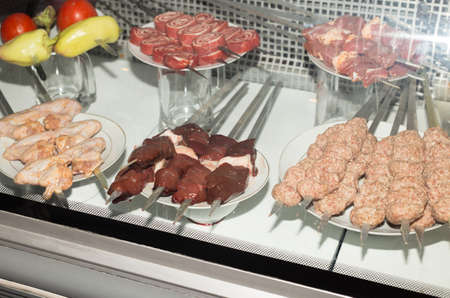 different kebabs in a transparent refrigerator choice for customers in the cafeの写真素材
