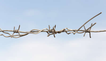 barbed wires against blue sky.の写真素材