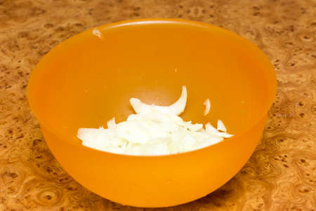 chopped onions in a plastic bowlの写真素材