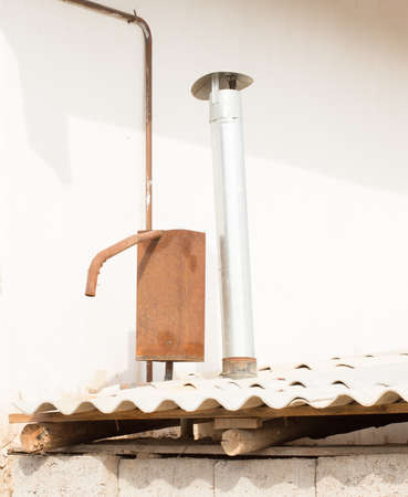expansion tank and chimney pipe on the asbestos roofの写真素材