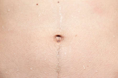 The background of a person's stomach with a drop of waterの写真素材