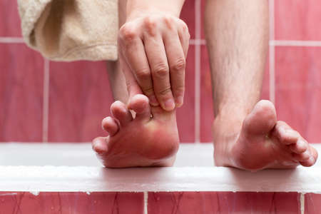 A man cleans his foot in the bathroomの写真素材