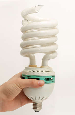 Broken light bulb in hand on a white backgroundの写真素材