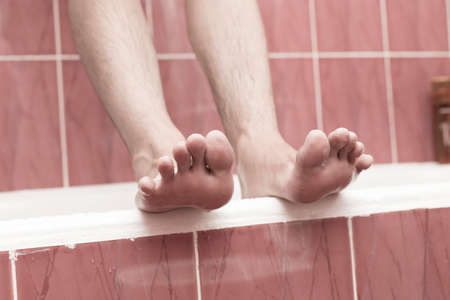 A man cleans his foot in the bathroomの写真素材