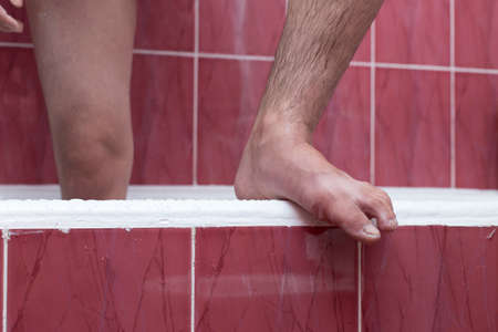 A man cleans his foot in the bathroomの写真素材
