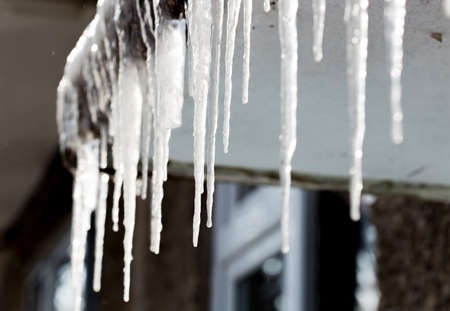 Icicles hang down from a building roofの写真素材