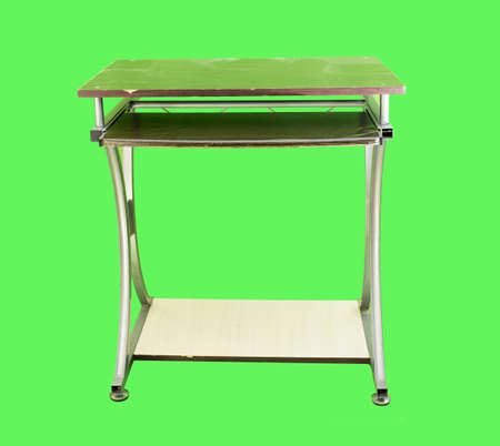 Old computer desk isolated on a green backgroundの写真素材