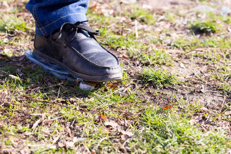 human trampled with the feet of plastic mineral water bottles and bottle caps on the grass in the park, the concept of environmental protection, fouling the environmentの写真素材