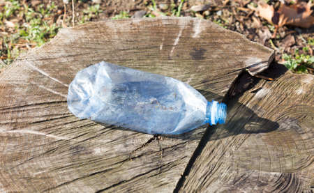 Shredded plastic mineral water bottles and bottle caps on the grass in the park, the concept of...