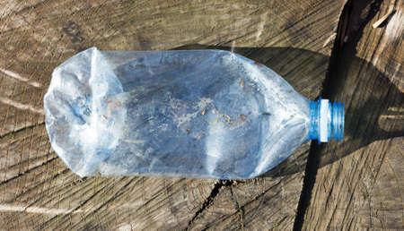 Shredded plastic mineral water bottles and bottle caps on the grass in the park, the concept of environmental protection, environmental protection cloggingの写真素材