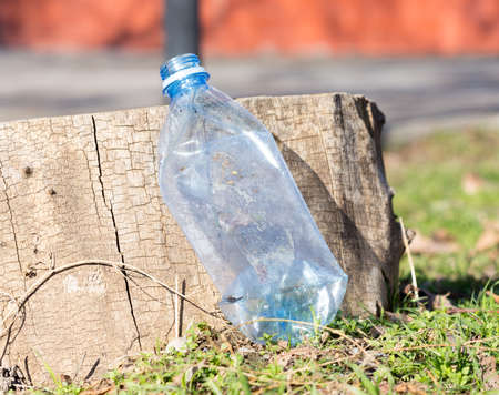 Shredded plastic mineral water bottles and bottle caps on the grass in the park, the concept of environmental protection, environmental protection cloggingの写真素材