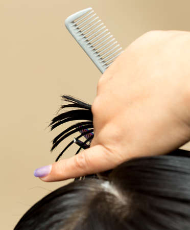 Closeup macro shot image of hairstylist hairdresser cutting customer woman hair in salon with...