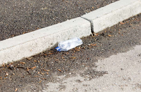 old plastic bottle lying on the sidewalk
