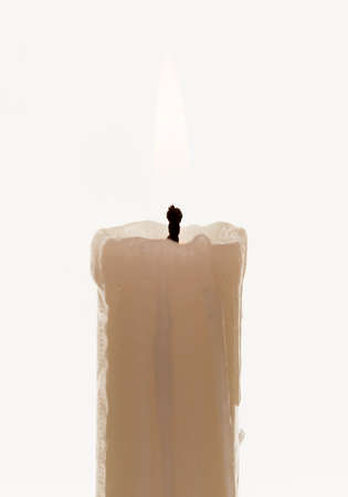 The candle burns brightly on the white backgroundの写真素材