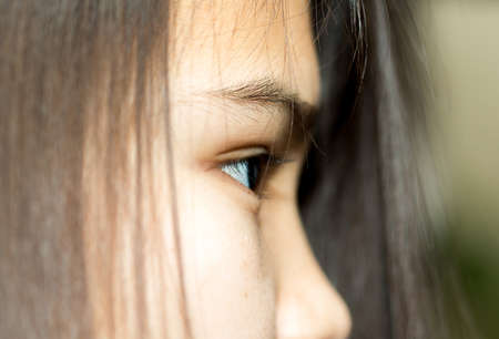 Close up of an attractive young woman looking through hair