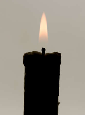 The candle burns brightly on the white backgroundの写真素材