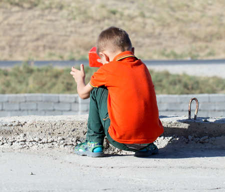 boy sitting and playing in the streetの写真素材