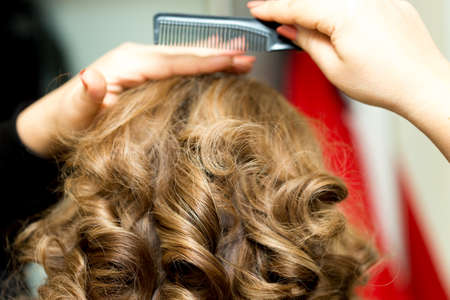 Girl combing her hair without looking at the cameraの写真素材