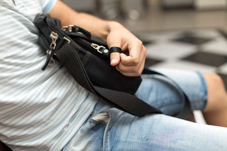 a man is afraid and sits in his hand a black purse with moneyの写真素材