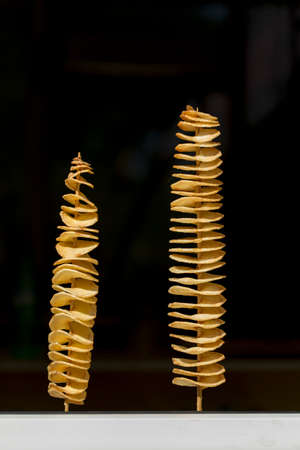fried potatoes, spiral form on a black backgroundの写真素材