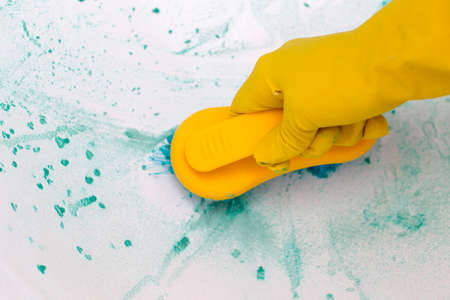 the girl cleans the surface in the bathroom. Girl holding a brush and cleaning herの写真素材