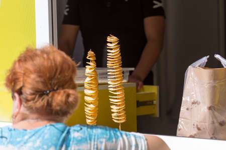 woman buying chips with a spiral shapeの写真素材