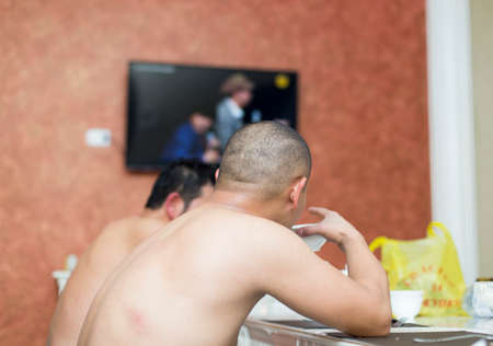 naked man sitting in the sauna on the table and drinking drinks
