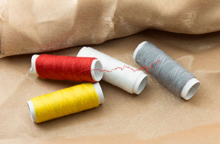 Several bobbins on a background of brown cloth