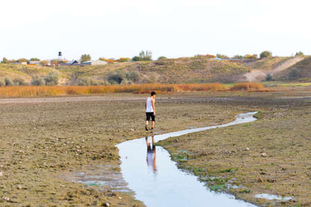A young man walks in dirty, salty ecological placesの写真素材