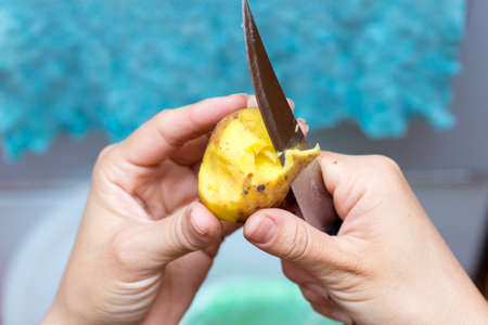 A girl is pealing potatoesの写真素材