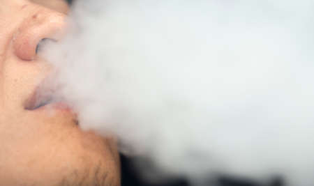 smoke hookah from the mouth of a man
