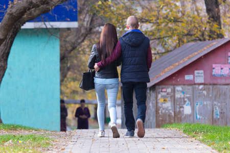 autumn, lovers walk on the sidewalks