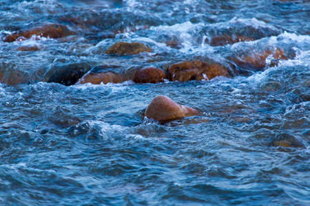 a stream of mountain water on a river with stones