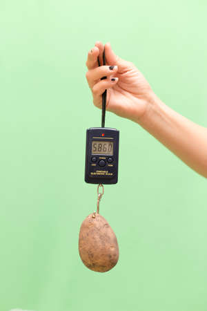 potatoes and hand scales on a green background