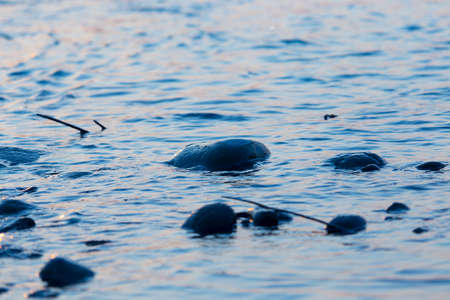 the stream of water during sunset and the beautiful stones on it