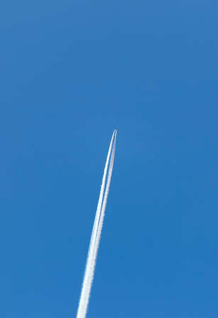 airplane with traces in the skyの写真素材
