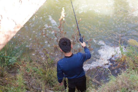 a man is fishing near a riverの写真素材
