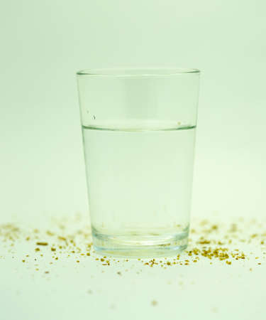 bread crumbs and a glass of water on a white background