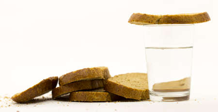 Rye bread and a glass of water on a white backgroundの写真素材