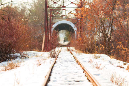 A man and a woman walk along the railway and exit the tunnel. Light at the end of the tunnelの写真素材