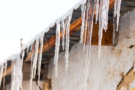 icicles hanging from the roof or pipes in winterの写真素材