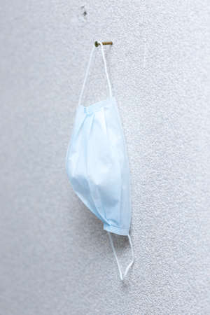 medical mask hanging on a screwの写真素材