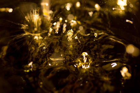 crown formed by a water spray on a gold background