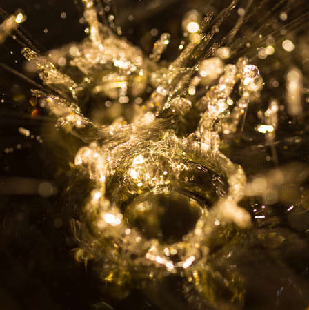 crown formed by a water spray on a gold backgroundの写真素材