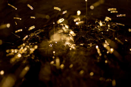 crown formed by a water spray on a gold background