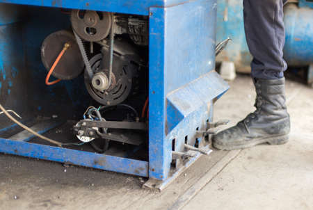 engineer balancing car wheel on balancer in workshop