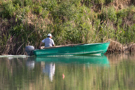 a man drives a motor boat on the lakeの写真素材
