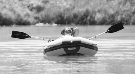 father with children riding on an inflatable boatの写真素材