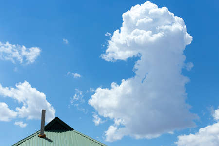 Blue sky with clouds over the roof of the house