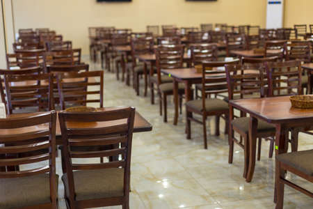 a lot of wooden, brown chairs in a cafeの写真素材